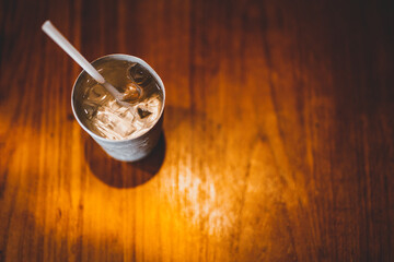 water with ice in vintage cup with wooden table background