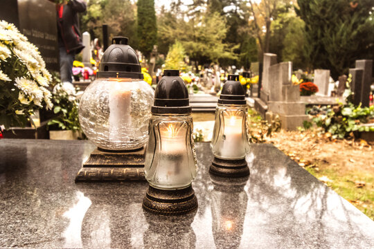 All Saints day and burning candles concept in the cemetery