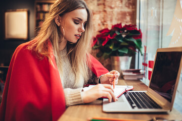 Female student doing homework sitting at desktop using laptop computer for online courses, skilled freelance professional planning successful strategy for startup working remotely in cafeteria