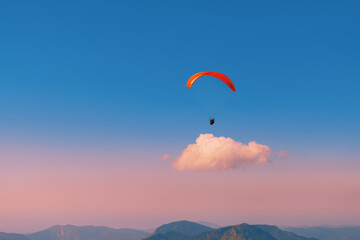 Paragliding against the sky during sunset. Flying over the mountains. Aircraft. Paraglider above...