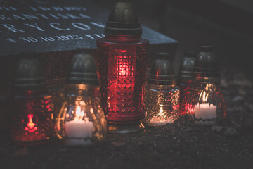 All Saints Day concept, burning candles in lanterns in the cemetery with night atmosphere