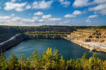 Fototapeta premium Abandoned granite and sand quarry with a lake. Stone extraction in the canyon.