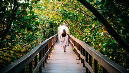 Woman taking a walk down a boardwalk