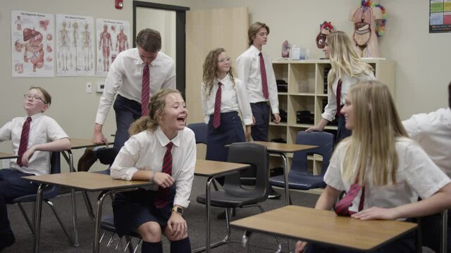 Secondary School Students In UK Enter Class And Sit Down At Their Desks