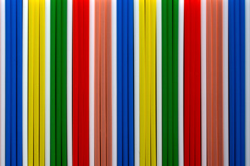 top view of multi coloured  plastic  drinking straws in a row