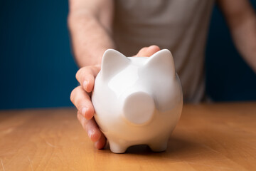 piggy bank in hand on table
