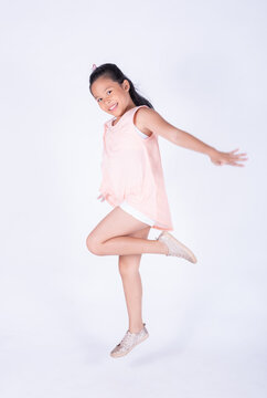 Happy children posing jump over white background. Asian child girl post in studio isolated. funny little kid girl childhood, fun and motion concept