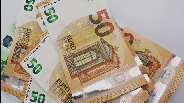 euro banknotes new coins stacked on top of each other to pay the bill, slow motion