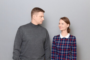 Portrait of happy woman and serious man looking at each other
