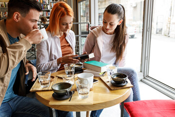 Group of university students hangout in college cafe library and preparing for lecture.	
