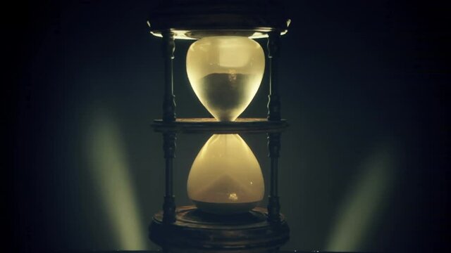 Sand falling from the top of a magnificent hourglass (an ancient device for the measurement of time). Backlit timelapse.
