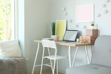 Workplace with modern laptop in the interior of the room