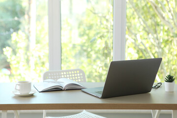 Workplace with modern laptop in the interior of the room