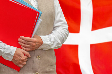 Woman holding red folder on Denmark flag background. Education and jurisprudence concept in Denmark
