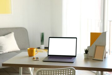 Workplace with modern laptop in the interior of the room