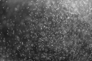 snow or rain bokeh texture overlay on black background.