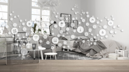 Tablet wireless with smart home app on wooden table, geometric background with connected line and dots showing internet of things system, home automation concept over modern bedroom