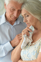 Portrait of sick elderly woman and man at home