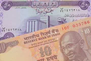 A macro image of a orange ten rupee bill from India paired up with a purple fifty dinar bill from Iraq.  Shot close up in macro.