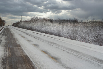 Snow covered asphalt road in rural Prince Edward Island, Canada.