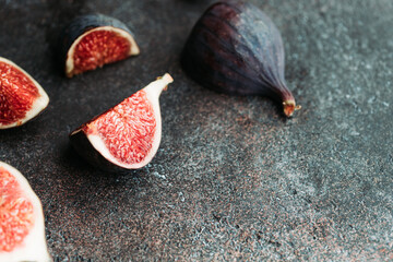 Macro photography of fresh ripe cutted figs on the textured background.