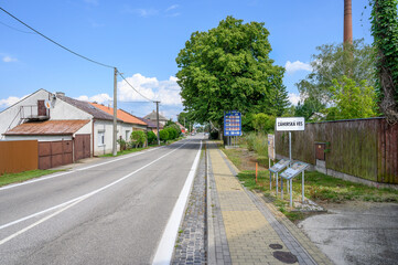 Entrance road to village Zahorska Ves with big blue board with speed limits in Slovakia (SLOVAKIA)