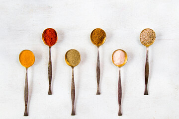 variation of spices on the vintage silver spoons, all spices on the table