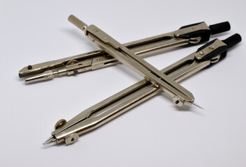 Three compasses on a white background. Isolated, close-up.
