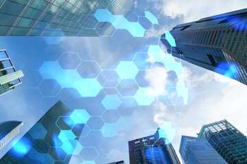 Fototapeta na wymiar Abstract technology icons hologram on low, wide angle view of glass and steel contemporary skyscrapers in financial downtown. The concept of success in hi-tech industry. Double exposure.