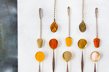 variation of spices on the vintage silver spoons, all spices on the table