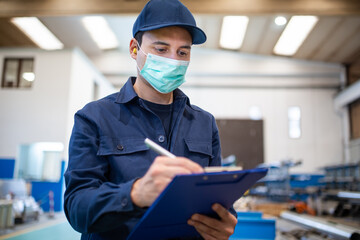 Industrial worker writing on a document