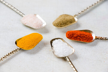 variation of spices on the vintage silver spoons, all spices on the table