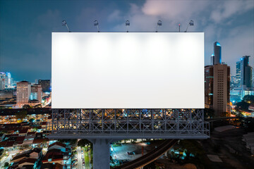 Blank white road billboard with KL cityscape background at night time. Street advertising poster, mock up, 3D rendering. Front view. The concept of marketing communication to promote or sell idea.