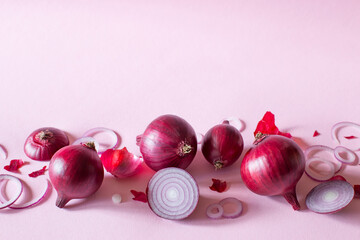 Fresh red onion on a pink background, close-up, copy space.