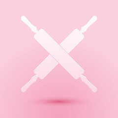 Paper cut Crossed rolling pins icon isolated on pink background. Kitchen utensils and equipment. Paper art style. Vector.