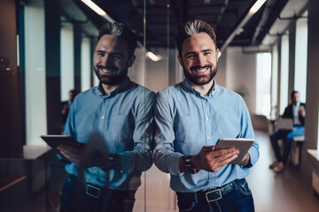 Smiling businessman holding tablet smiling at camera