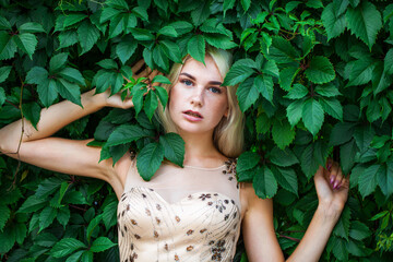Young beautiful blonde in ivy, summer park outdoors