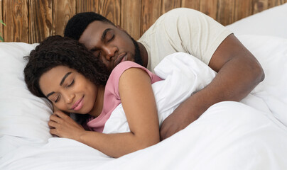 Obraz na płótnie Canvas Peaceful african couple sleeping in their bed