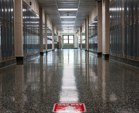 Empty High School Hallway With One Way Sign On Floor