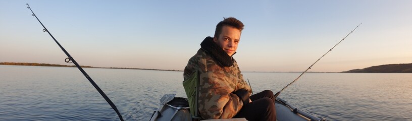 teen boy drives a motorised PVC boat, fishing on trolling.