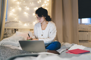 Focused female freelancer taking notes