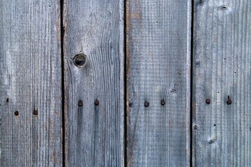 Viejas tablas de madera de una valla desgastada y tosca al aire libre. Primer plano de madera cortada con nudos y estropeada por el paso del tiempo.