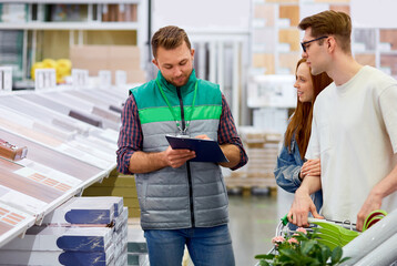 responsive warehouse worker consult customers in the market, man in uniform helps people, give them...