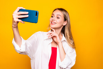 Young woman using cellphone have video call over yellow background