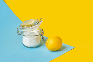 can of soda and lemon on yellow-blue background copy space