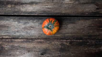 Homegrown orange squash pumpkin placed on rustic wooden boards