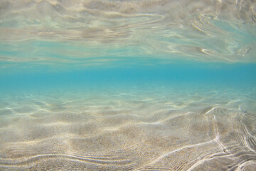 Fototapeta na wymiar Underwater view of sand beach in sea tropical lagoon with clear turquoise water. Natural background