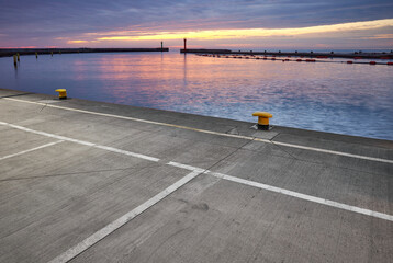 Lit parking lot at a harbor during the blue hour.