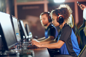 Fototapeta na wymiar Team of professional teenage cyber sport gamers participating in eSports tournament