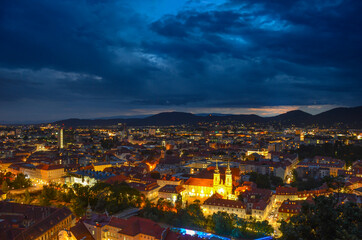 Storm with dramatic clouds over the city of Graz, with Mariahilfer church and historic buildings, in Styria region, Austria